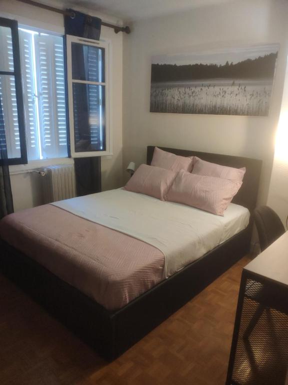 诺瓦西勒塞克Le noisy的一间卧室配有带粉红色枕头的床