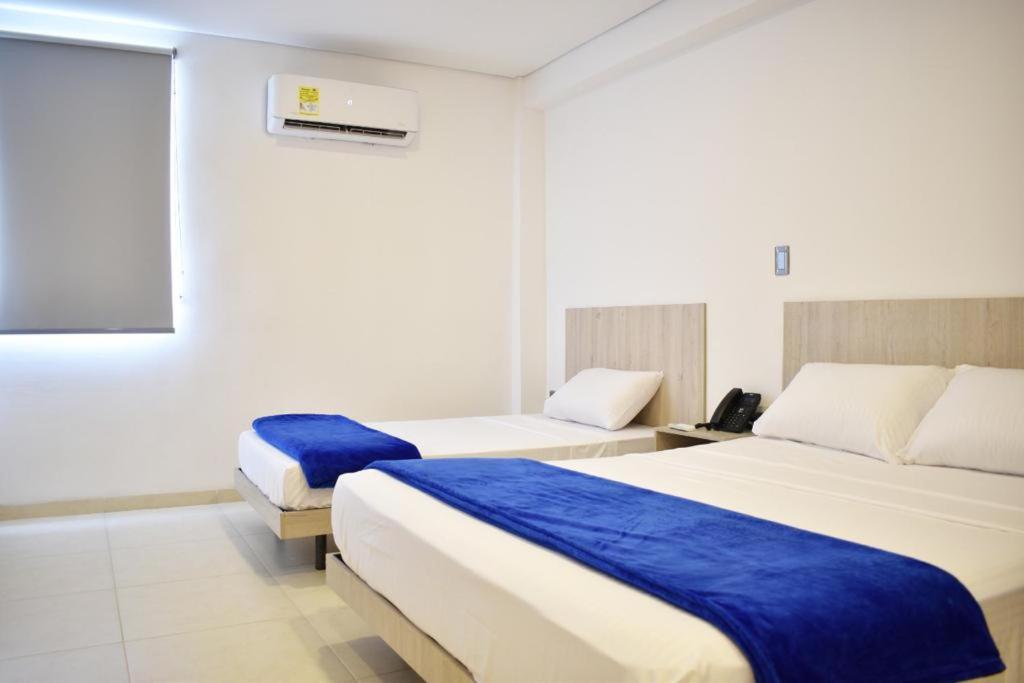 库库塔Hotel Blu Cúcuta的酒店客房,配有两张带蓝色床单的床