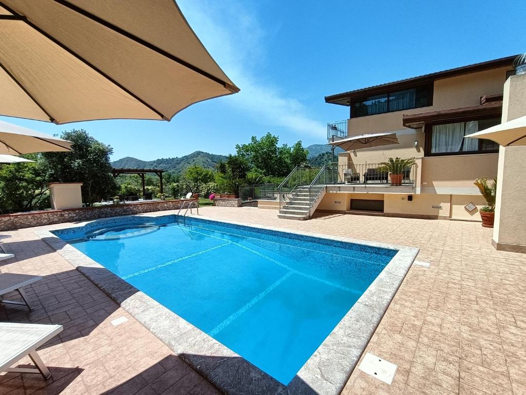 佳吉Villa Gloria的一座带遮阳伞的房屋前的游泳池
