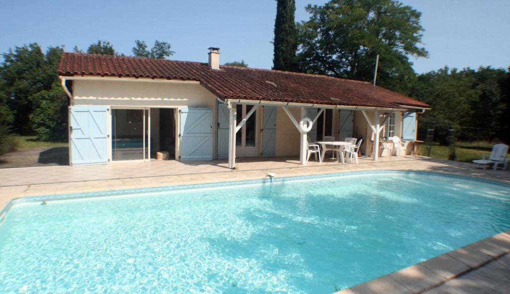 圣昂托南La petite maison du Bosc的大楼前带游泳池的房子