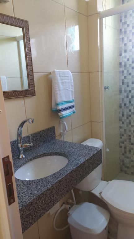 萨尔瓦多Suíte Porto das Dunas的一间带水槽、卫生间和镜子的浴室