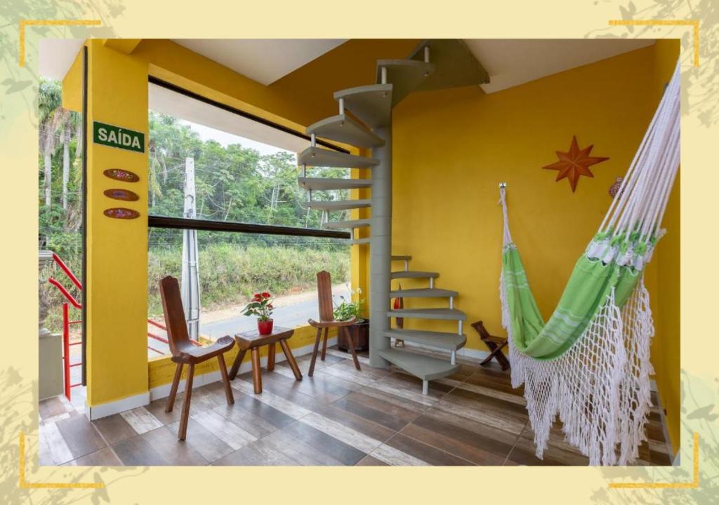 佩尼亚Pousada Dona Elena的客房设有吊床和黄色墙壁。