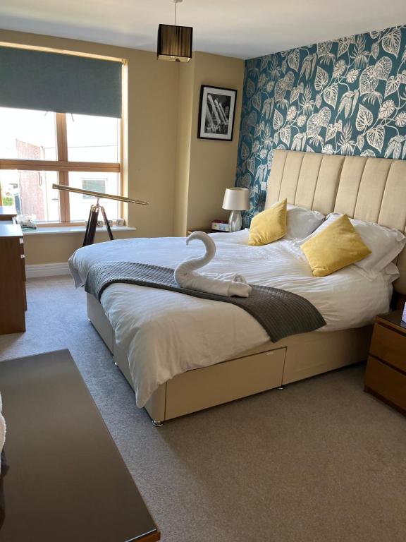 戈斯波特Stunning Marina apartment Gosport Portsmouth的一间卧室配有一张大床,上面有天鹅