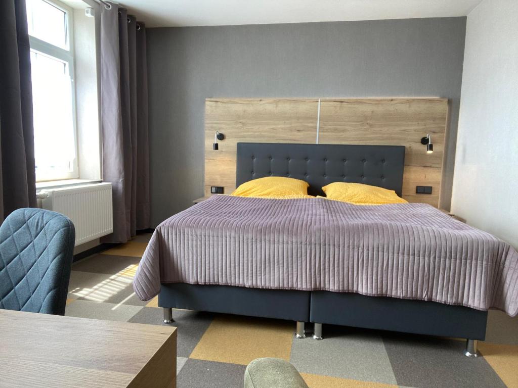 蒙绍Gästehaus Bendsieferhof的一间卧室配有蓝色的床和黄色枕头