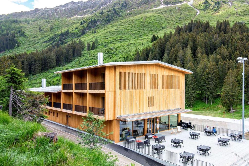 OlivoneCampra Alpine Lodge & Spa的山前带桌椅的建筑