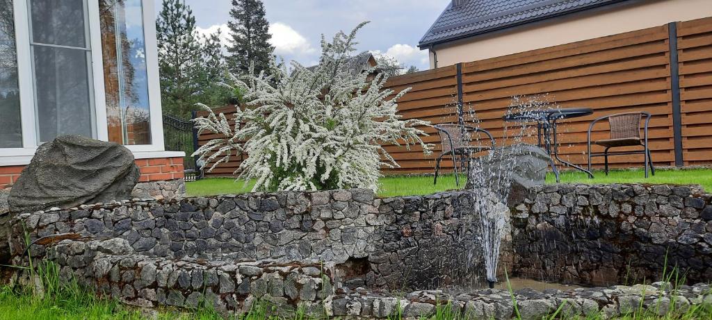 维尔纽斯Verkių Namelis的房屋前方有喷泉的石墙