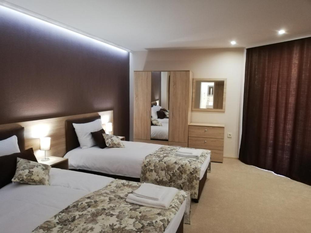希普卡Хотел Бялата роза的酒店客房,设有两张床和镜子