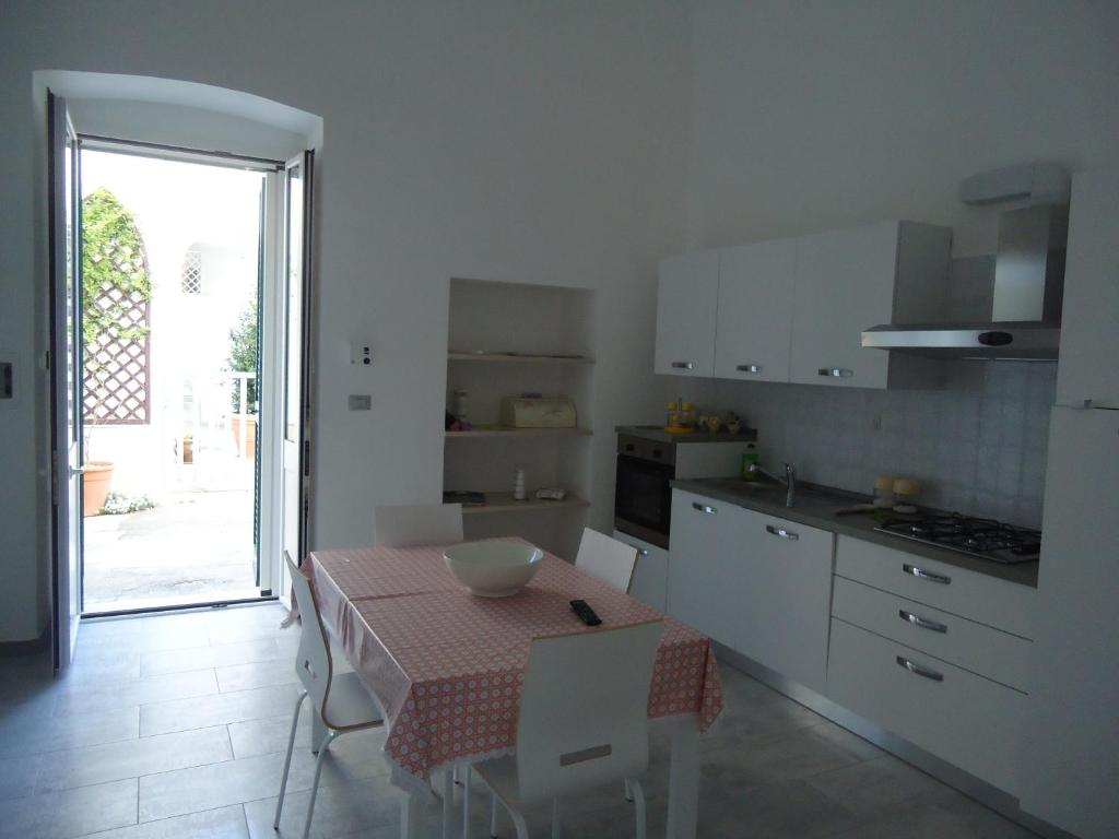 莱乌卡Appartamento Leuca的厨房配有桌子和桌椅