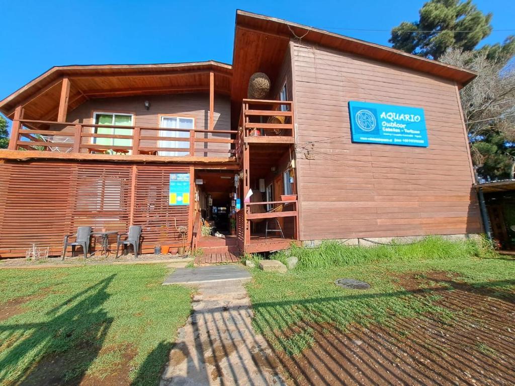 帕普多Cabañas Hostel Aquario Papudo的小木屋设有阳台,前面配有椅子