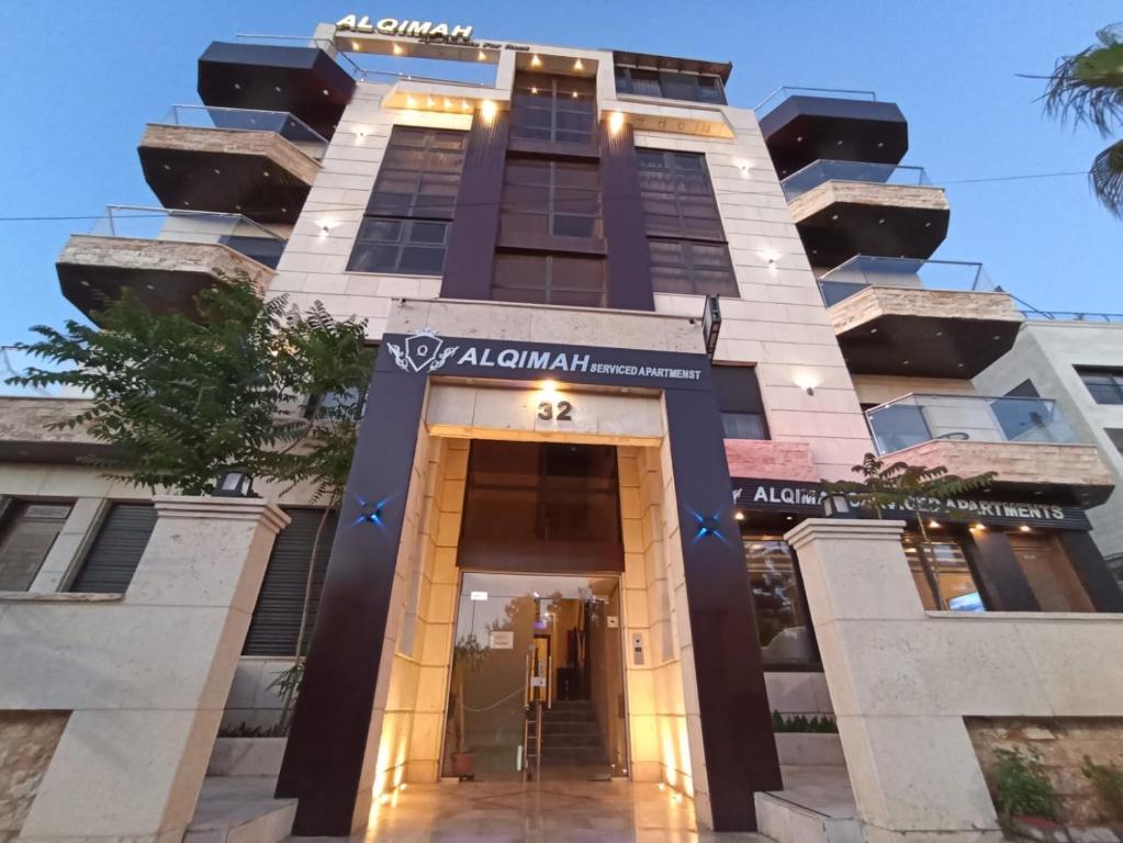 安曼AlQimah Hotel Apartments的a building with the entrance to akhtar hotel