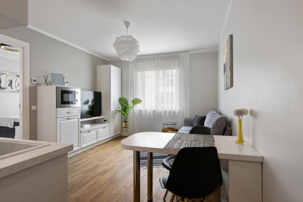塔林Brand new, cozy and quiet 1 br apartment, free parking的厨房以及带桌椅的起居室。
