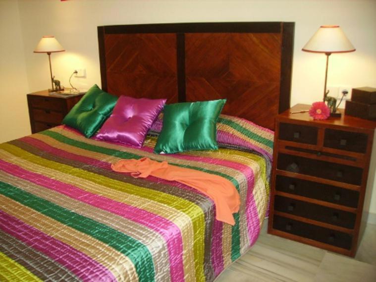卡拉德米哈斯Málaga, Mijas, La Cala, apartamento vacaciones de ensueño的一张带绿色和紫色枕头的床