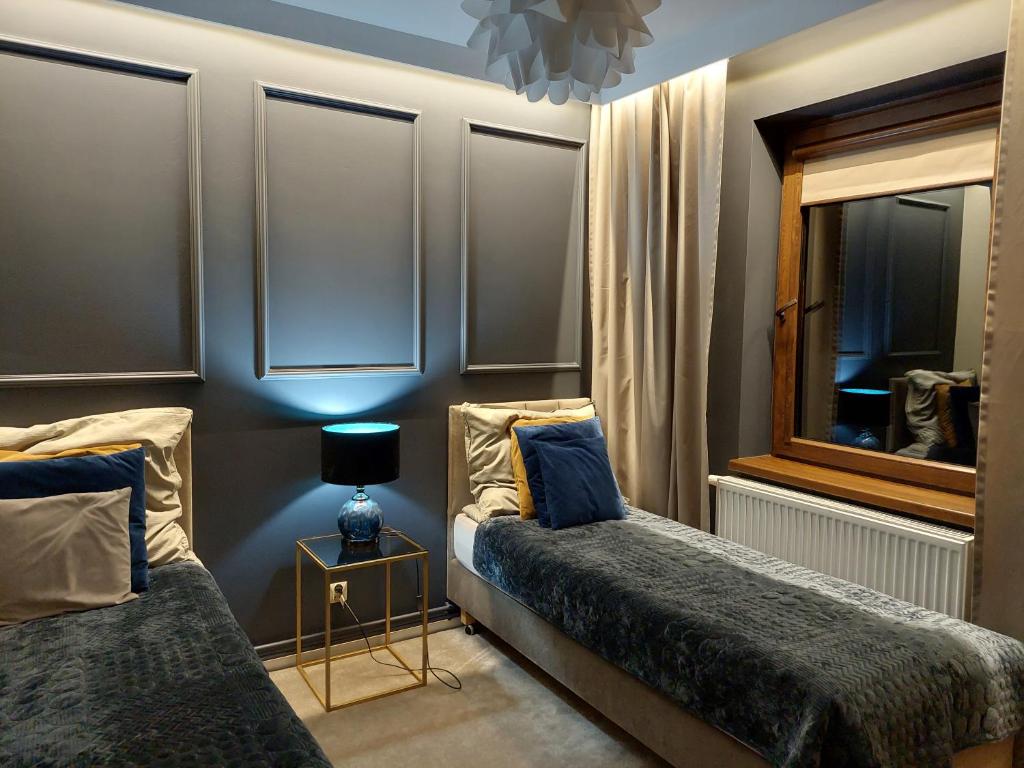 圣凯瑟琳Nowoczesne domki z kominkami, sauną i fotelem masującym Bayamo, Lucca, Hawana I i Hawana II的一间卧室设有两张床和窗户。
