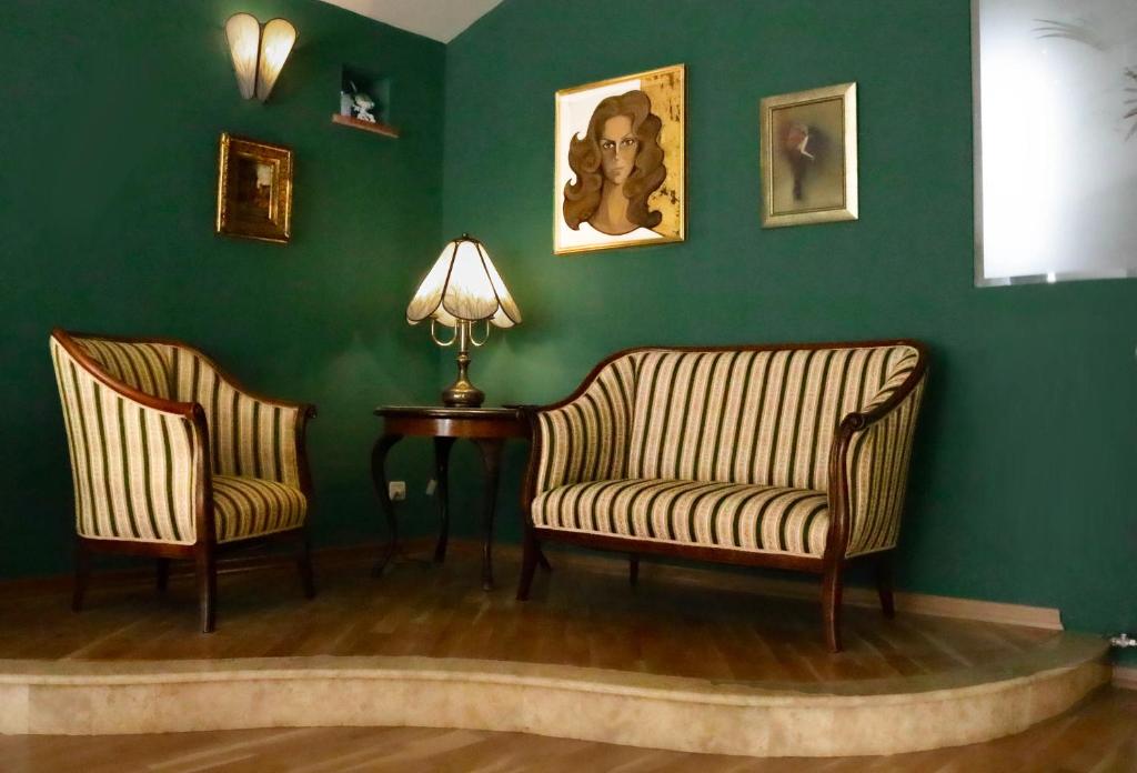 斯普利特Luxury Spalato Garden的绿墙客房内的2把椅子和桌子