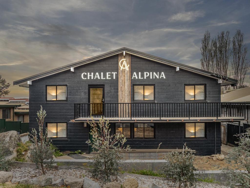 金德拜恩Chalet Alpina的一座黑色的建筑,上面写着粉笔字