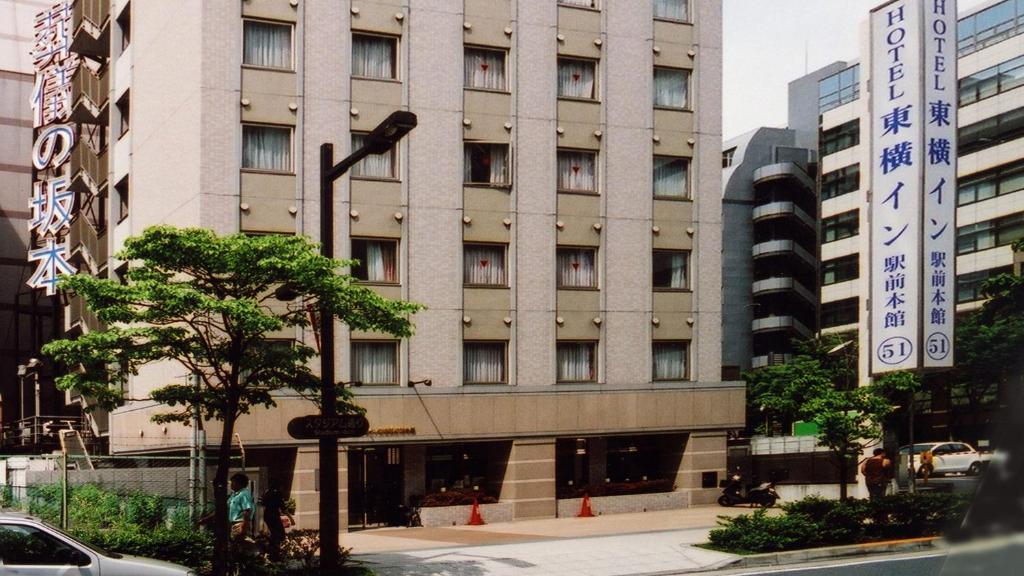横滨Toyoko Inn Shin-yokohama Ekimae Honkan的前面有标志的大建筑