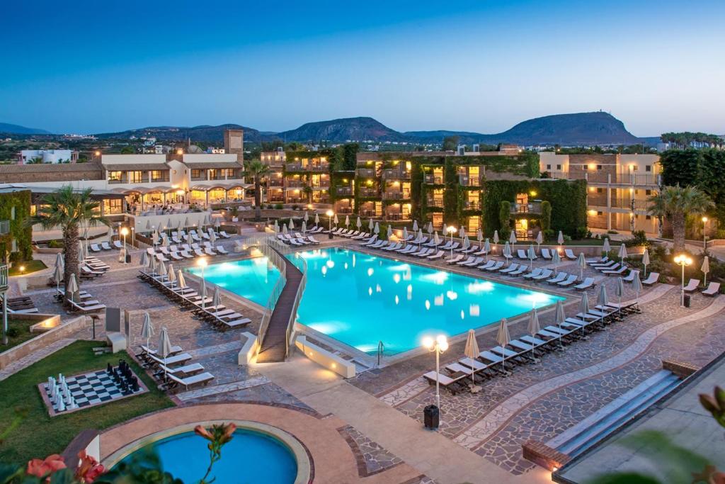 赫索尼索斯贝拉海滩酒店的一座带躺椅的大型游泳池,位于大楼内