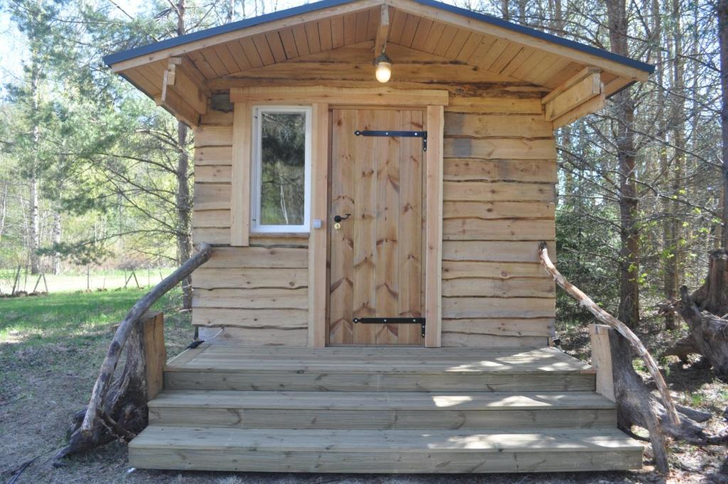 KorjuseKorjuse Moori metsaonn- forest hut的木房子,有门和楼梯