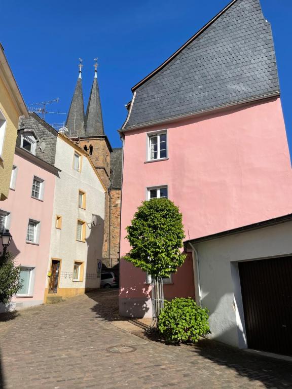 萨尔堡Uriges Ferienhaus in der Altstadt von Saarburg mit Sauna, Kinderspielecke, 1000Mbit Wlan, 1 Minute vom Wasserfall entfernt的街道上一棵树的一群建筑