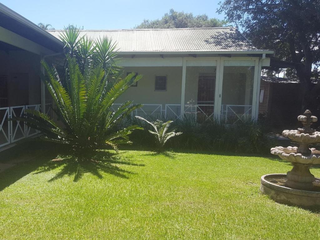 PelhamAlexandra Bed & Breakfast的院子里两棵棕榈树的房子