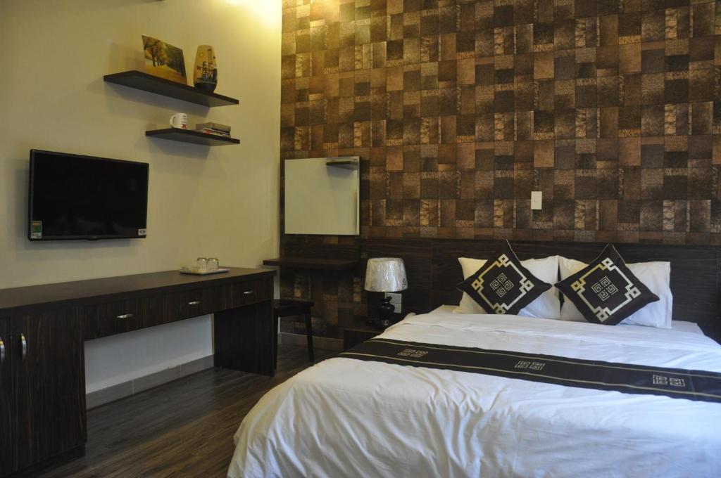 海防玫瑰酒店的一间卧室配有一张床和一台平面电视