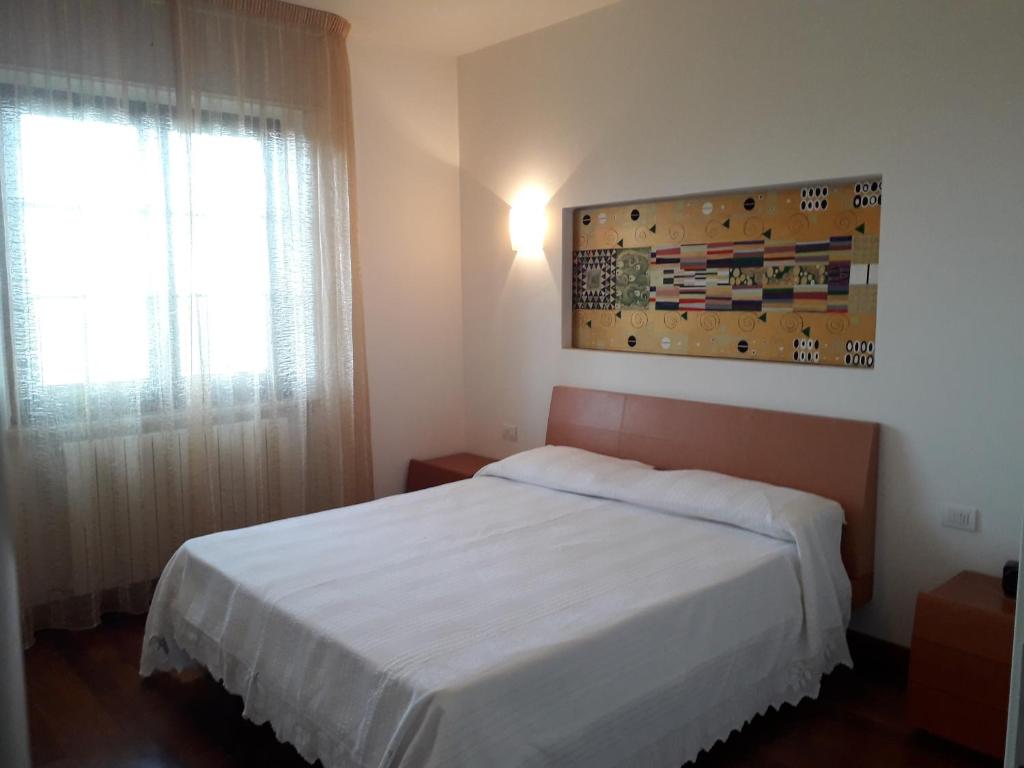 奇维泰拉-德尔特龙托Villino Sabina的卧室配有白色的床和窗户。