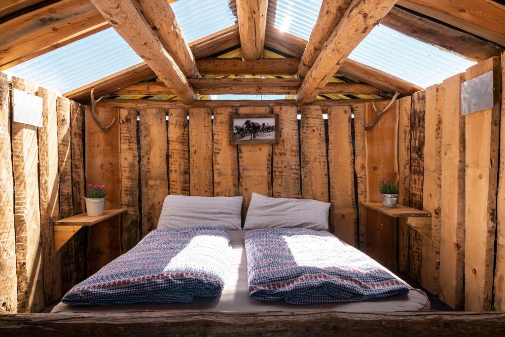 MalmigiuerTgamon Somtgant mit Glasdach的木屋中间的一张床
