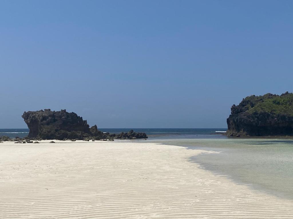 瓦塔穆Watamu Shell House的海洋中岩石的沙滩