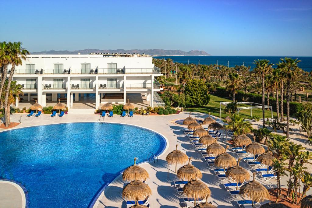 雷塔马尔Hotel Cabogata Jardín的一个带游泳池、椅子和遮阳伞的度假村