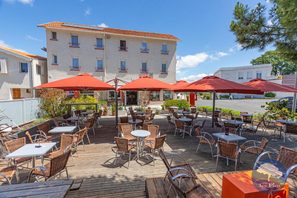 圣特罗让莱班勒斯宾酒店的一个带桌椅和红色遮阳伞的庭院
