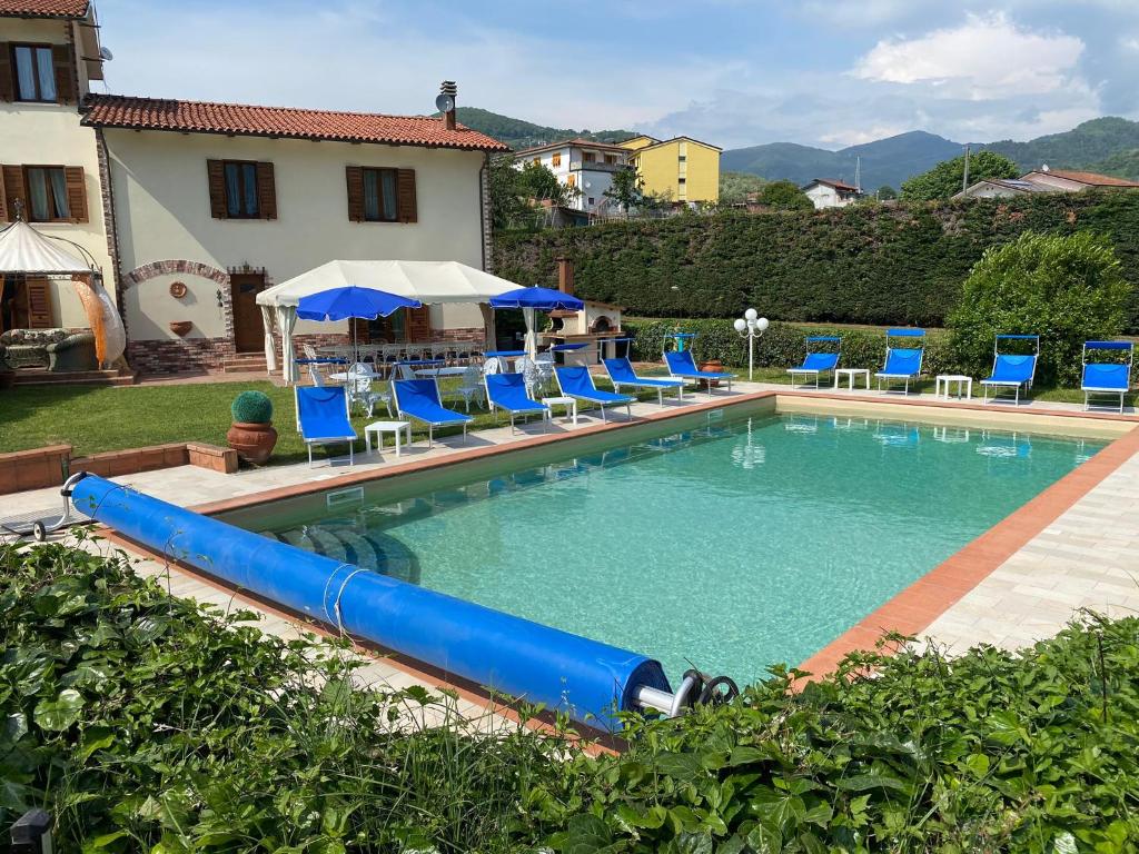 LuniVilla con piscina tra Versilia e Cinque Terre的一个带蓝色椅子和水滑梯的游泳池