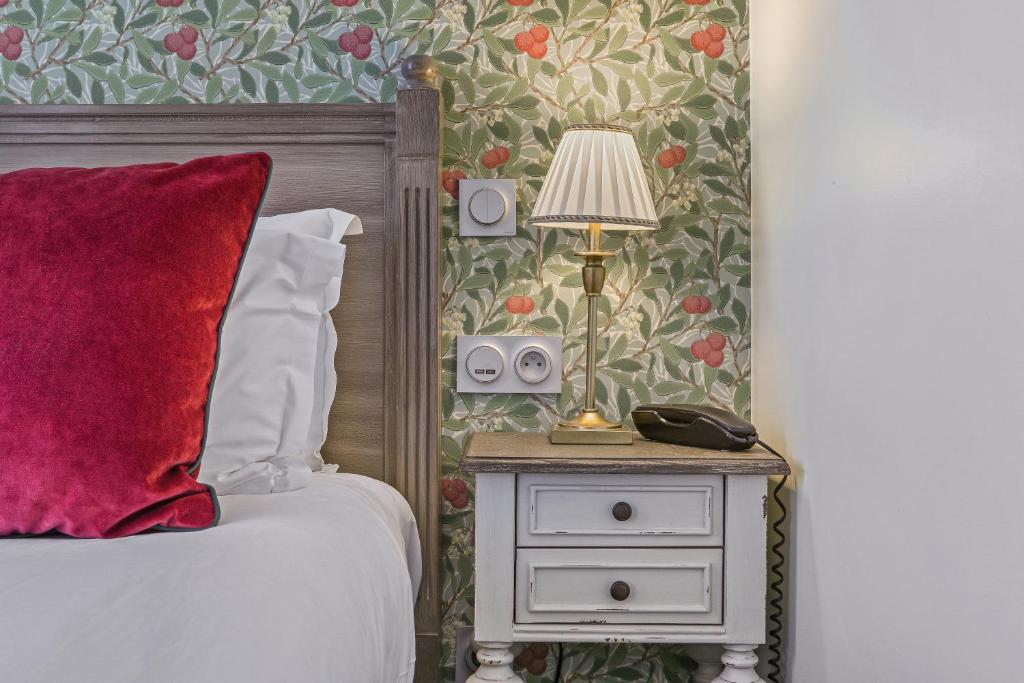 巴黎塞夫尔酒店的一间卧室,配有一张床和床头灯