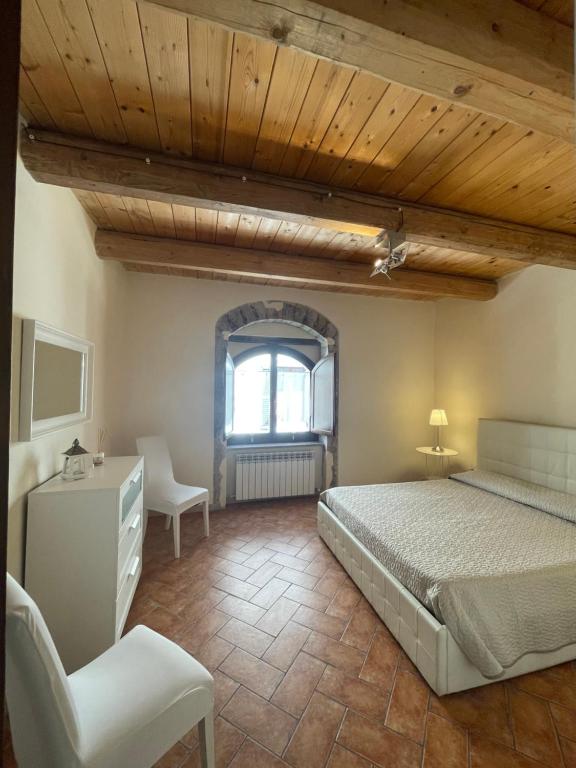 法布里亚诺Il Borghetto Medievale suite的卧室配有床、椅子和窗户。
