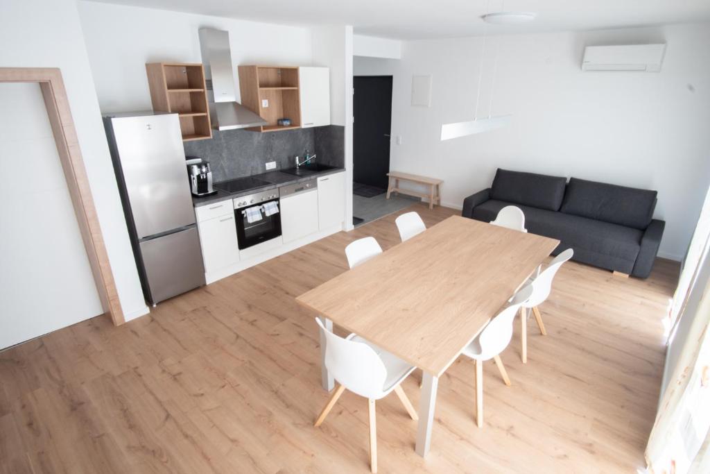 路茨曼贝格Family XL - Bungalows的厨房以及带木桌和椅子的客厅。