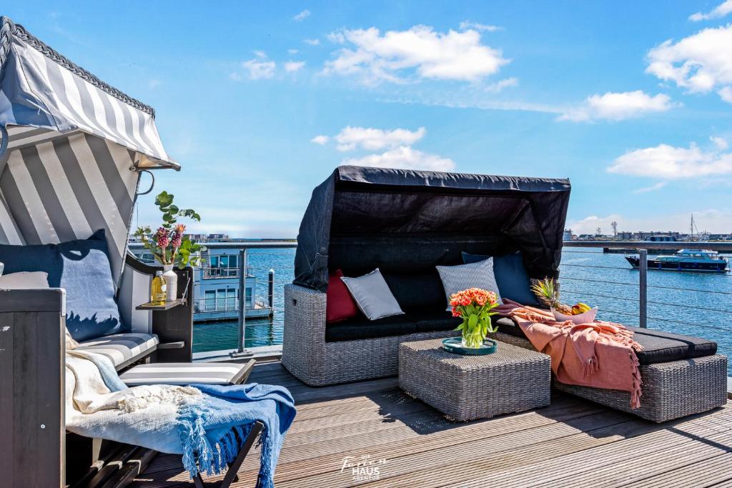 奥尔本尼兹Schwimmendes Haus Aloha的船上的甲板上配有沙发和桌子