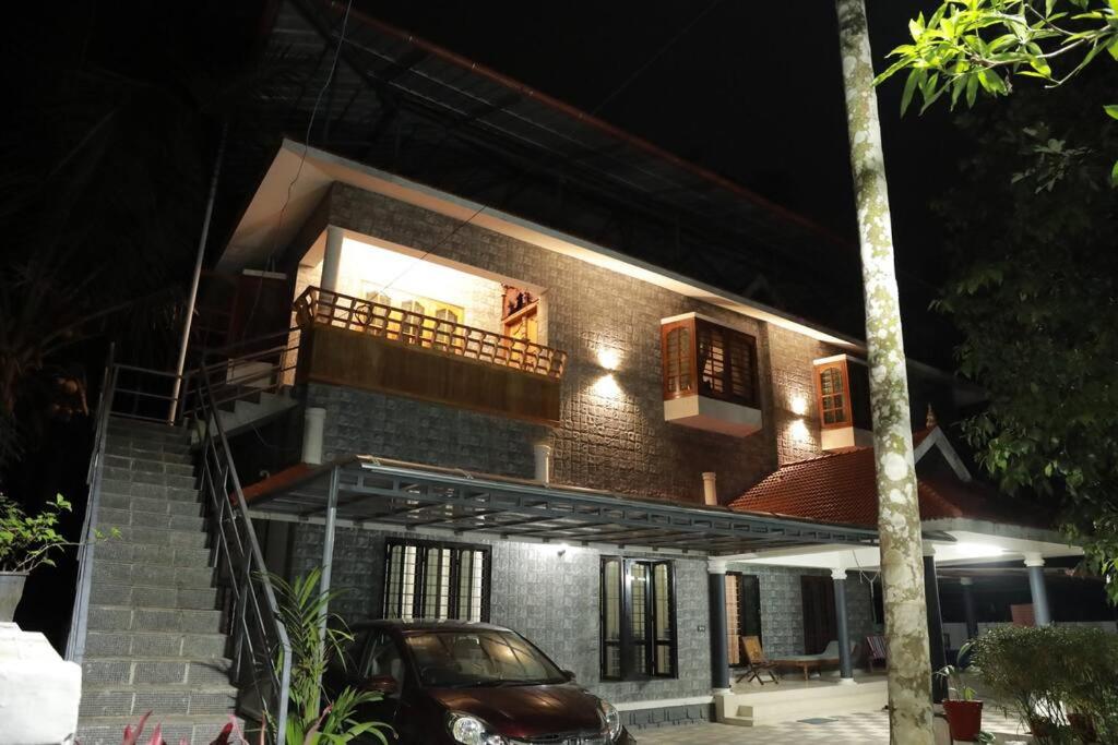 VaikomAnandam Stays - Premium 3BHK plush homestay, Vaikom near Kumarakom的砖屋,晚上设有阳台