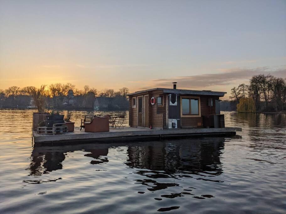 柏林Hausboot mit Hottub in Berlin的水面上的小房子