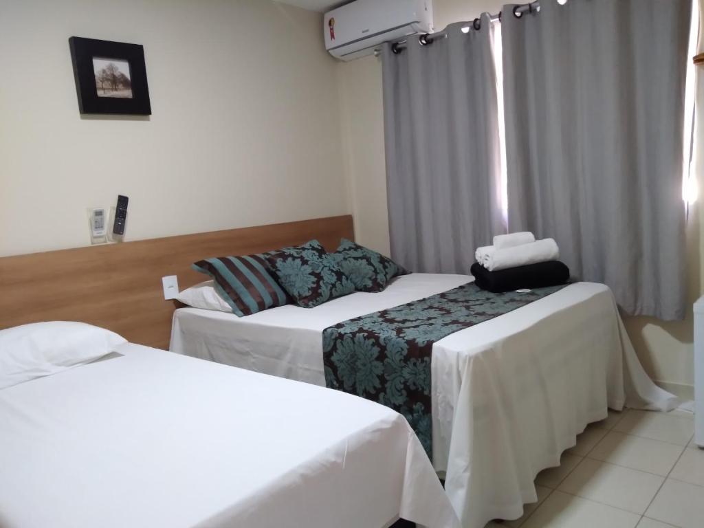 瓜拉派瑞Pousada Solar de Lourdes的酒店客房设有两张床和窗户。