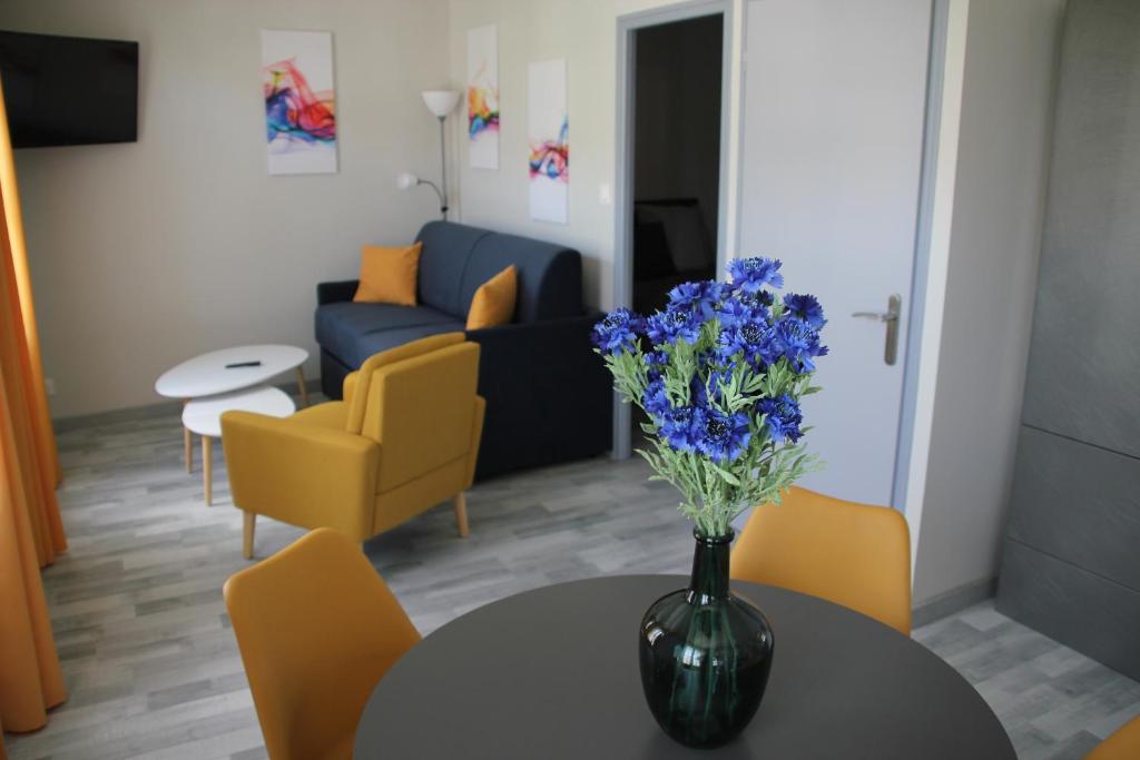 Arcis-sur-AubeLes appartements du Saint Hubert的客厅桌子上的一束蓝色花