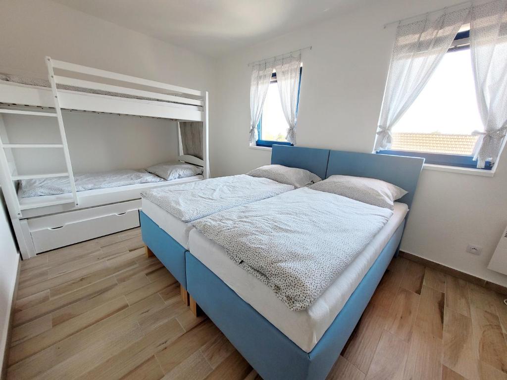 大帕夫洛维采Modrý sklep 77的一间卧室配有蓝色的床和一张双层床。