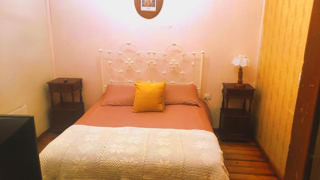 维库尼亚HOTEL Halley的一间卧室配有白色床和黄色枕头