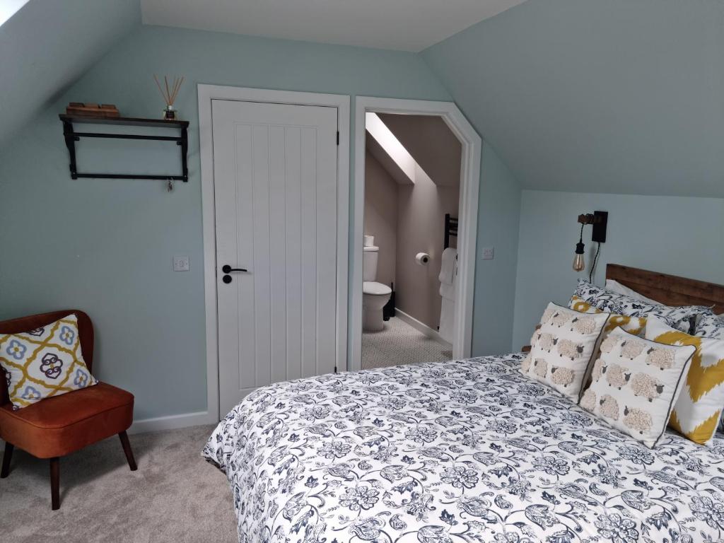 威廉堡Barra's Loft的一间卧室配有一张床和一把椅子