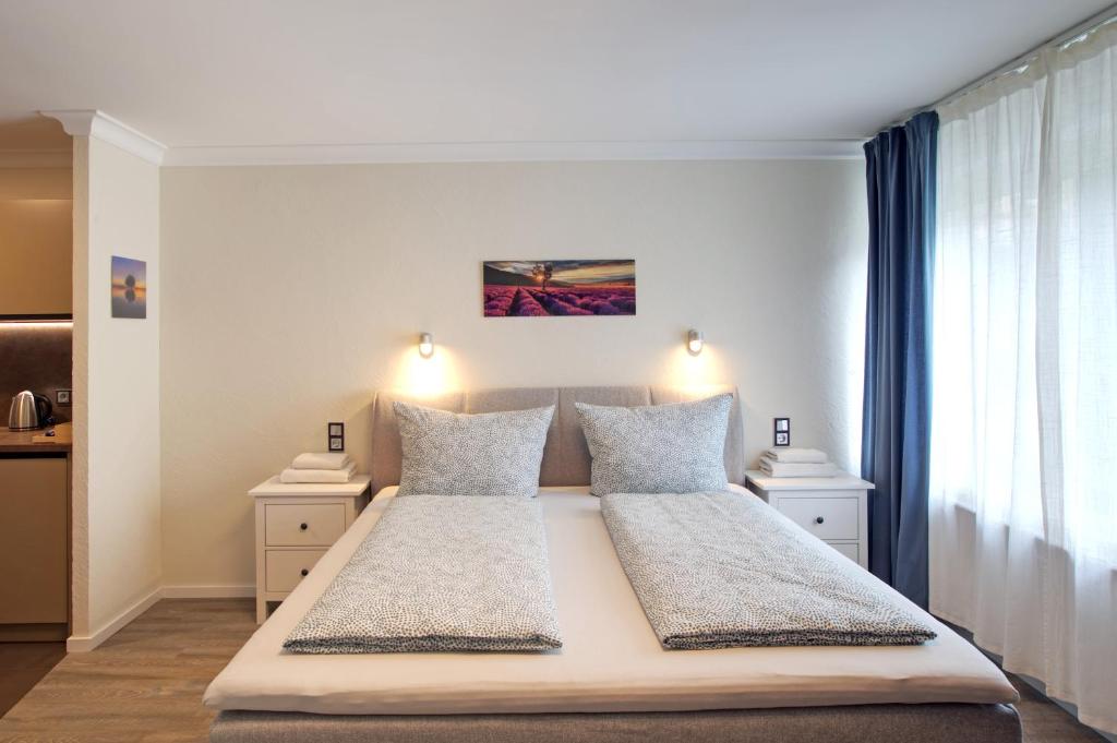 特里尔S.F.C. Apartments的一间卧室配有一张带两盏灯的大型白色床。