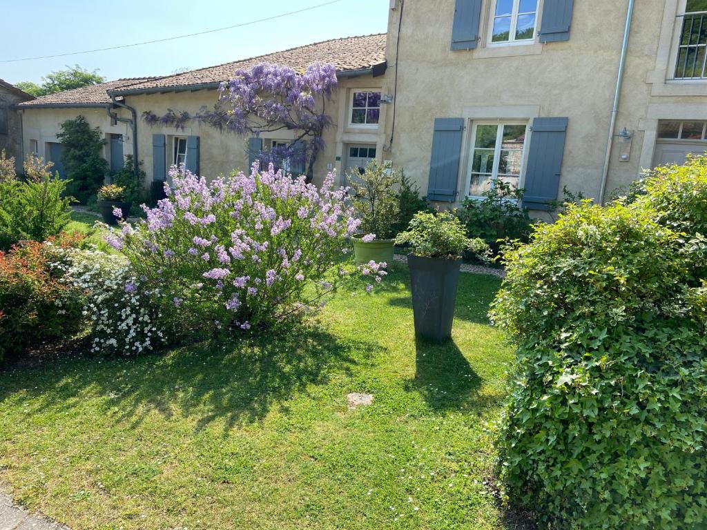 Viéville-sous-les-CôtesChambres d’hôtes la bottée的一座房子前面的院子,鲜花盛开