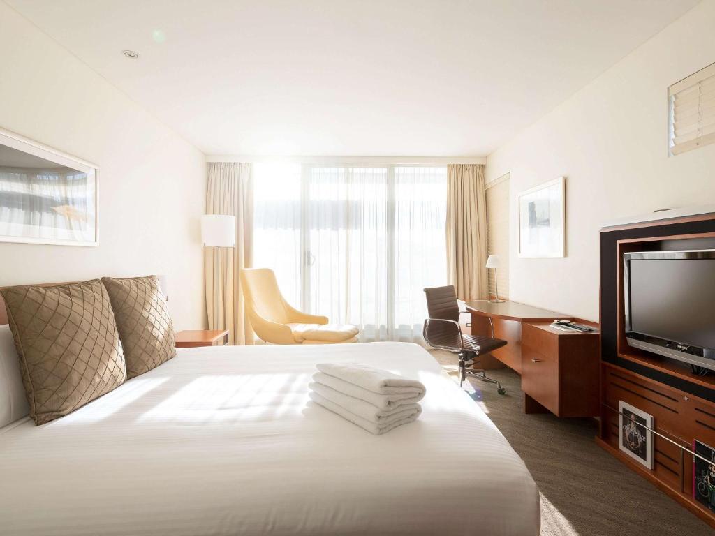 堪培拉诺富特堪培拉酒店的配有一张床和一台平面电视的酒店客房