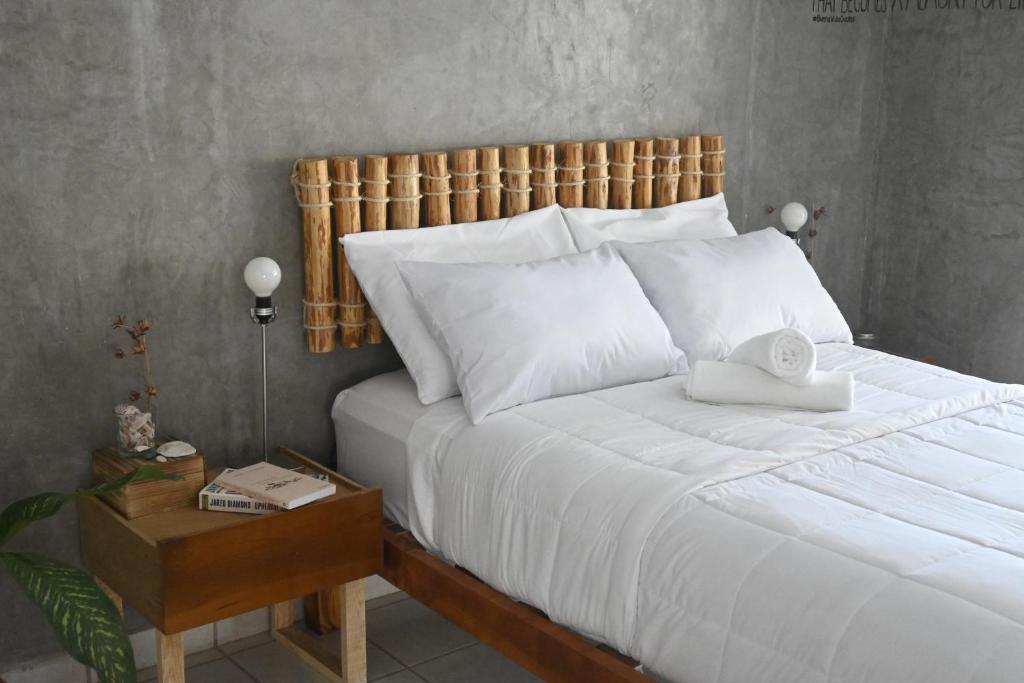 圣何塞德尔卡沃Desert Heart Hostel的卧室配有白色的床和木制床头板