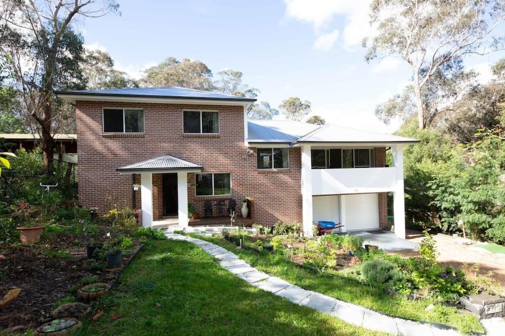 肯图巴The roses house - Cozy and Modern house in Katoomba的前面有花园的砖房