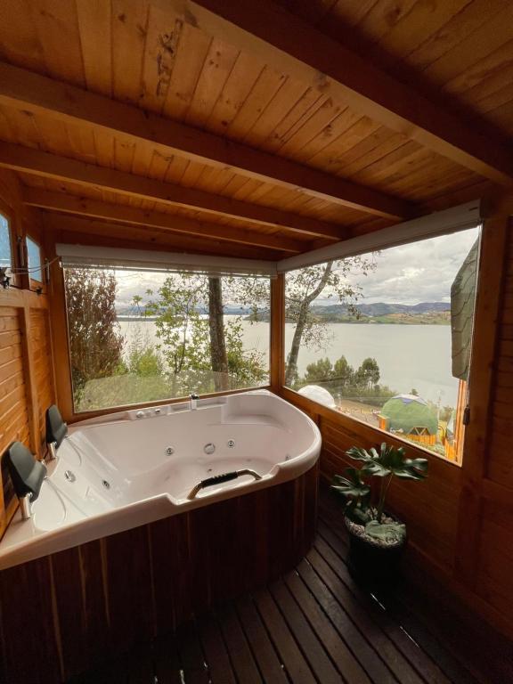 阿基塔尼亚Glamping Domos del Lago的设有一个大浴缸的大窗户