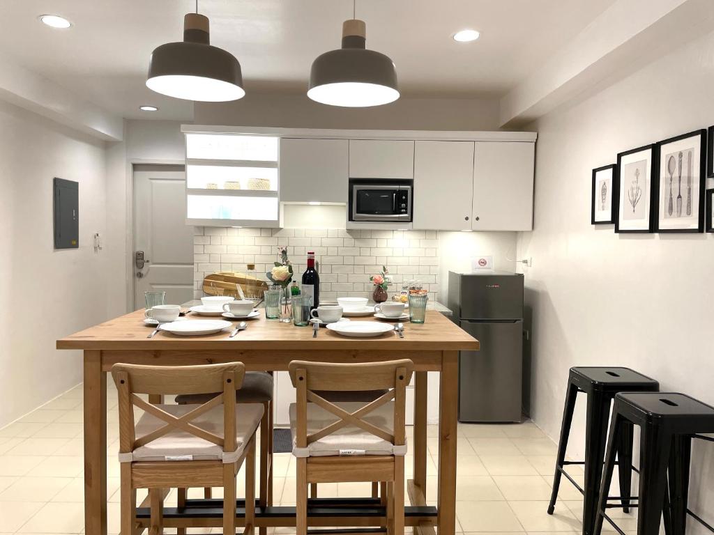 奥隆阿波CRIB 227: Modern Fresh Vibe Condo的厨房配有木桌、椅子和冰箱