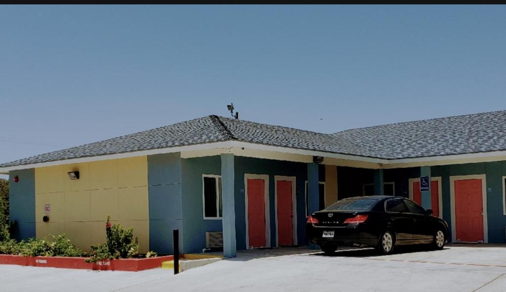 阿兰瑟斯帕斯Holiday Inn motel的停在大楼前的红色门的汽车